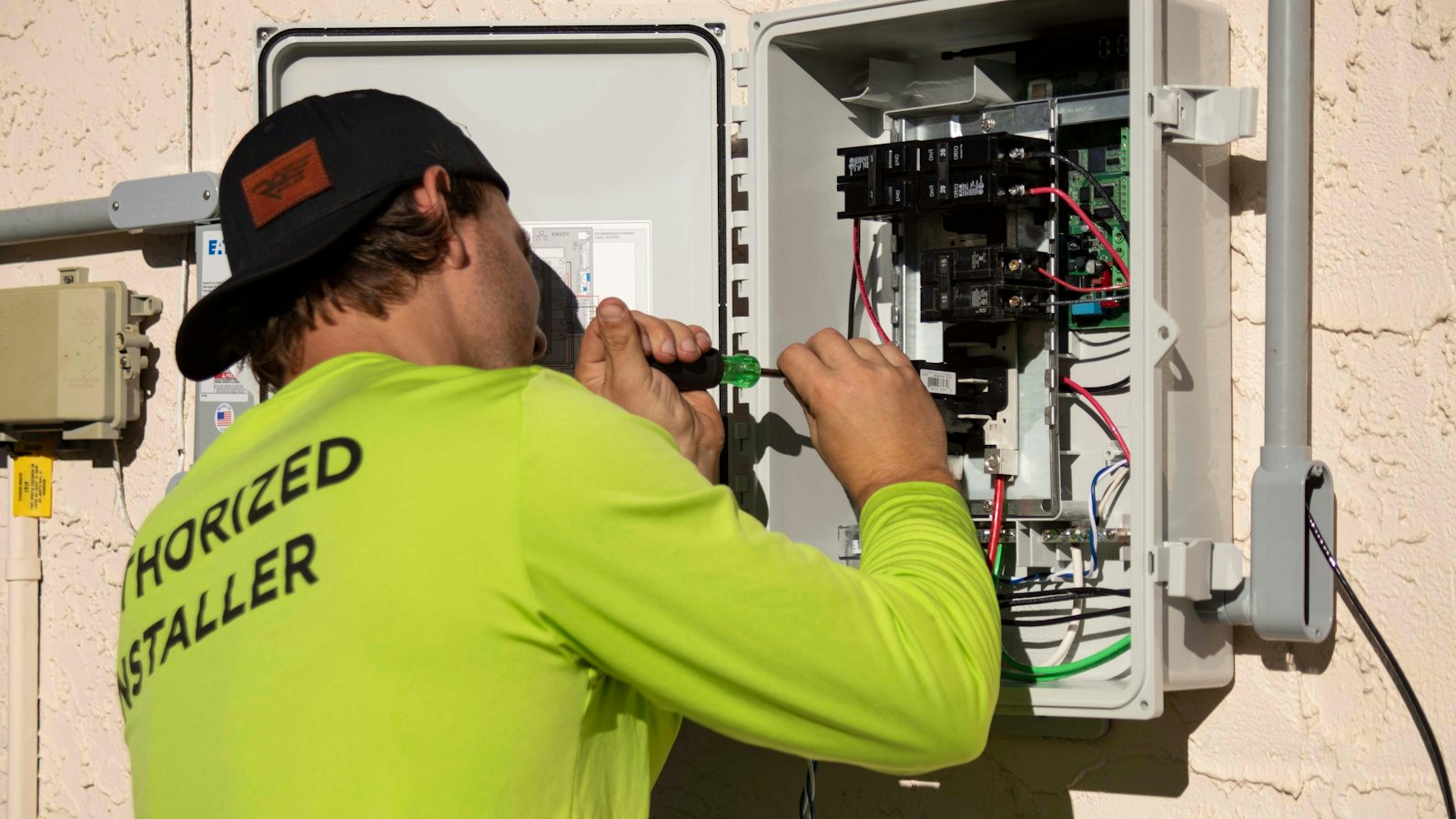 Elektriker arbejder på en eltavle med en skruetrækker