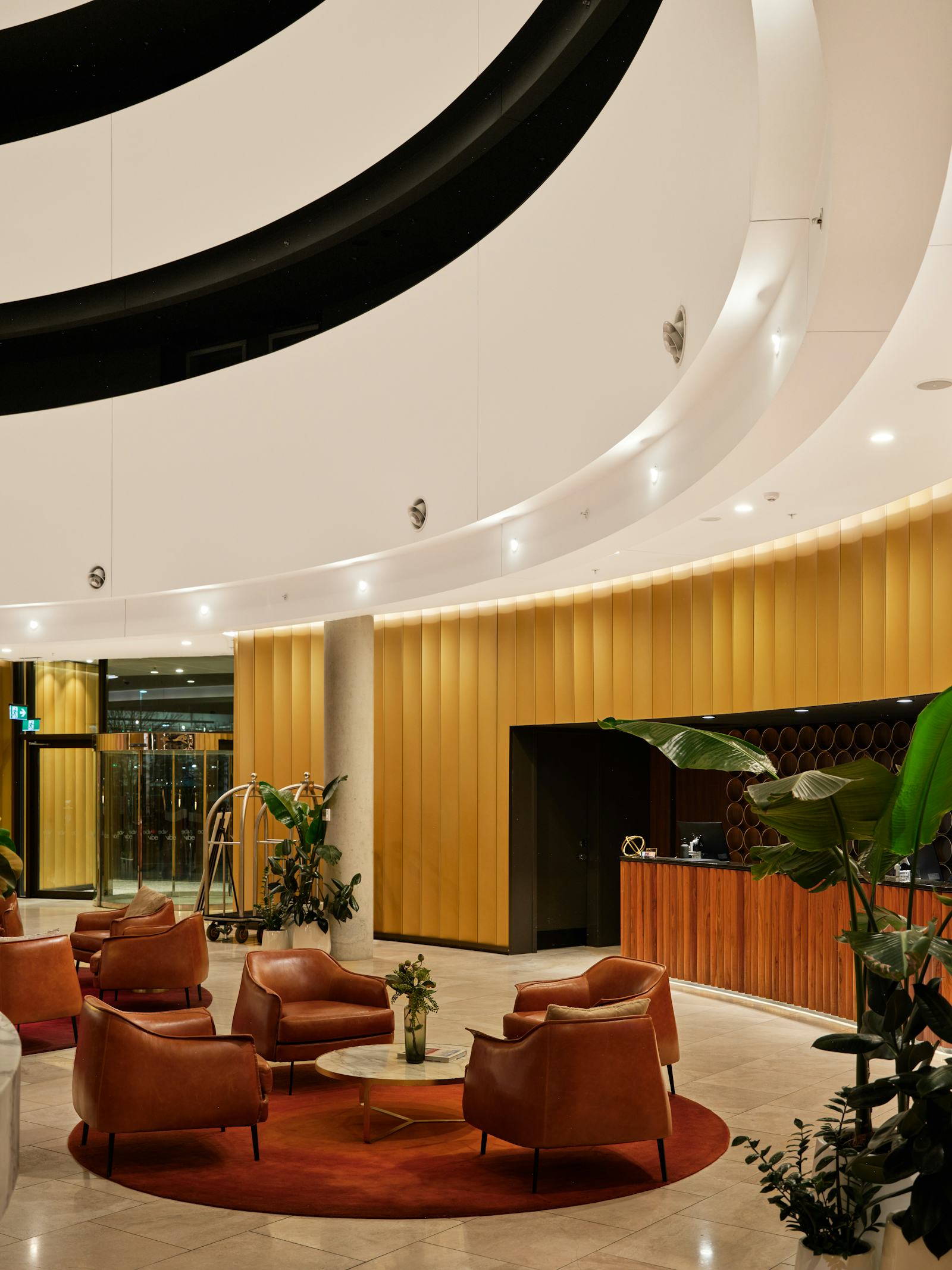 Moderne hotellobby med lædestole og en receptionsskranke